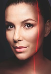 Gros plan sur un visage avec une peau lisse et claire. Yeux foncés et expressifs, lèvres pulpeuses. Une fine lumière rouge s'étire en diagonale sur la joue.