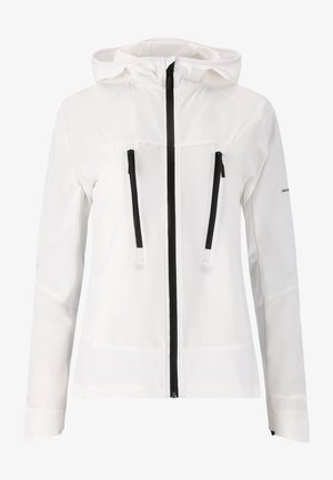 Witte buitenjas met een ritssluiting aan de voorkant, twee zwarte ritszakken en een capuchon. De stof lijkt zacht en lichtgewicht te zijn.