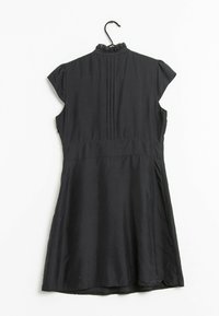 Schwarz Kleid mit kurzen Kapellenärmeln, einem gerafften Ausschnitt und vertikalen Nähten auf der Rückseite. Verfügt über einen schwingenden Rock mit einer glatten Textur.