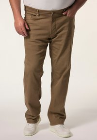 Pantaloni marroni a gamba dritta realizzati in tessuto misto cotone, dotati di passanti per cintura, cinque tasche e una superficie liscia. Indossati con sneakers bianche.