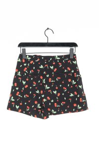 Pantalones cortos negros con un patrón de cerezas y hojas, que cuentan con dos bolsillos traseros y una textura suave. Exhibidos en una percha negra.