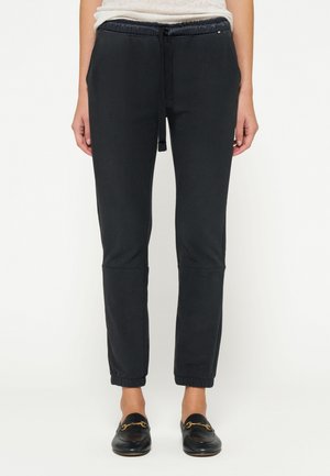 Pantaloni jogger neri a gamba affusolata realizzati in morbido tessuto, con vita elastica e coulisse, caviglie a costura e cuciture laterali.
