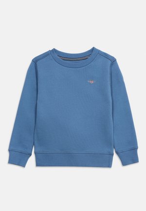 Sweat-shirt bleu à manches longues avec col rond, poignets et ourlet côtelés, présentant un petit logo brodé sur le côté gauche de la poitrine.