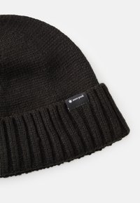 Black knitted beanie with a ribbed cuff, featuring a small rectangular label with the brand name "snow peak." Soft texture and warm design.