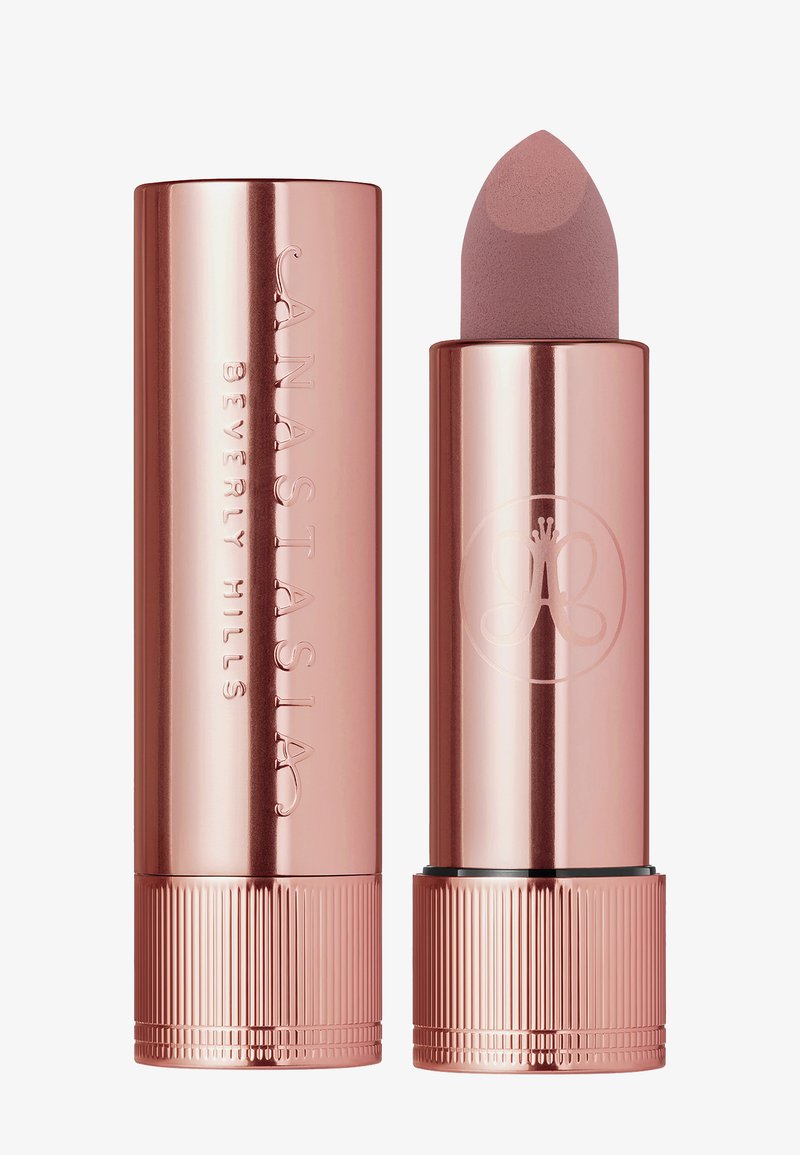 Roze gouden lippenstiftbuis met een ronde punt. Heeft een gegraveerde merknaam en logo, met een geribbelde basis voor grip. Gladde, metallic afwerking.