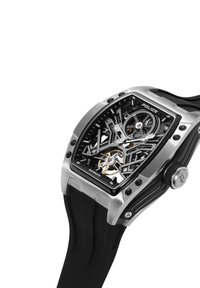 Črno in srebrno avtomatsko uro s skeletnim številčnico, pravokotne oblike, z gumijastim paščkom, kovinskimi poudarki in vidnimi gibajočimi se delci mehanizma.