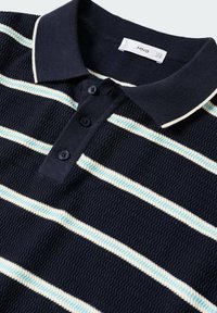 Polo bleu marine en tissu texturé, rayures horizontales blanches et bleu clair, patte de boutonnage, col côtelé avec bordure blanche.