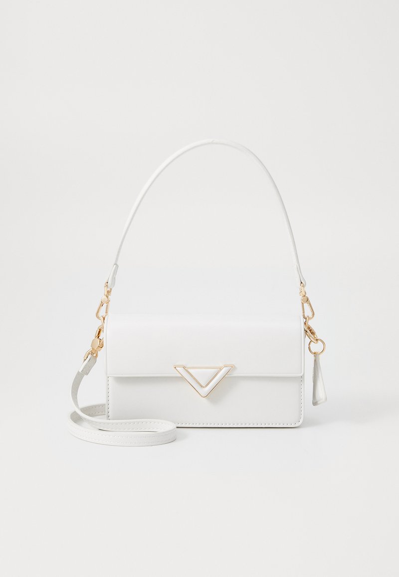 Sac à main en simili cuir blanc avec un accent en triangle doré, design plat, bandoulière amovible et un petit pendentif en frange accroché à la fermeture éclair.