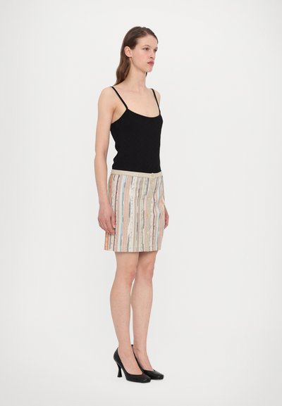 Black tank top with thin straps, paired with a patterned mini skirt featuring vertical stripes in pastel colors, finished with a button closure.
