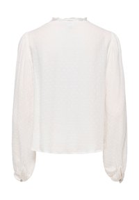 Λευκό μπλούζα με μακριά μανίκια, διακριτικές υφασμάτινες βούλες, σφηκοφωλιά με κουμπιά και μικρό ραμμένο γιακά με βολάν, εμφανιζόμενη από πίσω.