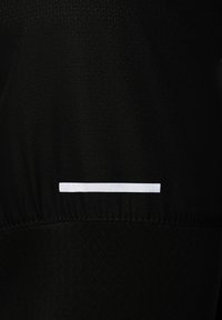 Tejido atlético negro con un patrón texturizado, que presenta una franja reflectante blanca horizontal a lo largo del borde inferior.