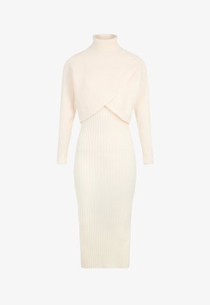 Vestido de punto color crema con cuello alto, mangas largas y un diseño frontal en capas. Presenta una textura acanalada y una silueta ajustada.