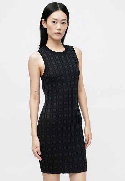 Rochie neagră fără mâneci cu un model texturat în grilaj, siluetă ajustată și guler din tricot. Tesătura are o finisare netedă și o ușoară elasticitate.