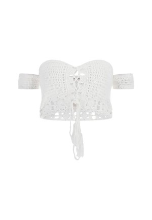 White crochet bandeau top with a lace-up front, open back, and fringe details. Features wide straps for support and a textured pattern.