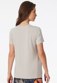 T-shirt grigio chiaro a maniche corte con scollo rotondo. Tessuto morbido, vestibilità comoda, mostrato di schiena senza marchi visibili.