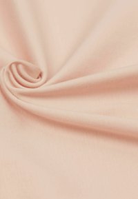 Tessuto rosa chiaro con una texture liscia, che mostra dolci pieghe e curve, evidenziando la sua qualità morbida e elastica.