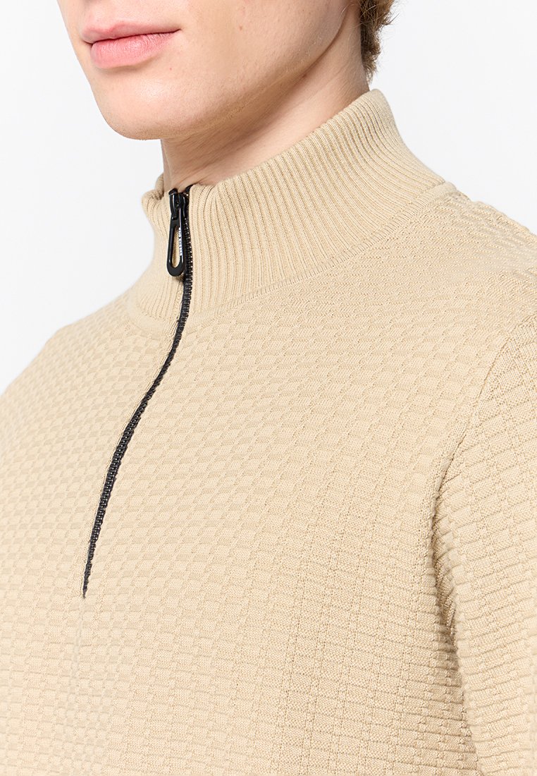 Beige Zip-up-Pullover mit geripptem Kragen und strukturiertem Rautenmuster. Verfügt über einen schwarzen Reißverschluss zum Verschließen.