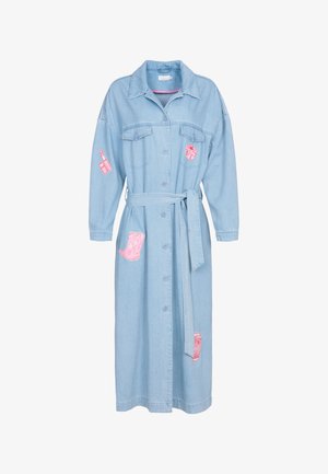 Robe en denim bleu clair avec des manches longues, des boutons sur le devant, une ceinture à la taille et des patchs brodés roses représentant un rouge à lèvres, une botte et une tasse.