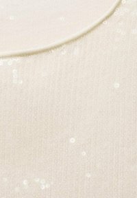 Tessuto color crema con una superficie liscia, caratterizzato da paillettes bianche sparse e un dettaglio sul collo arrotondato.