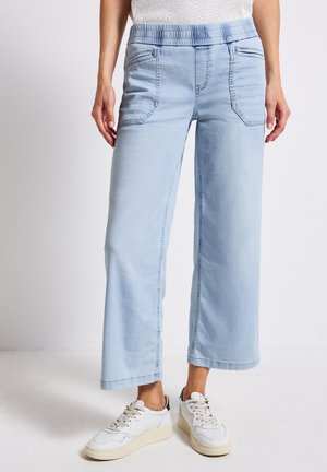 Hellblaue weit geschnittene Jeans mit elastischem Bund, zwei Fronttaschen, strukturiertem Stoff und genähten Details an den Nähten.