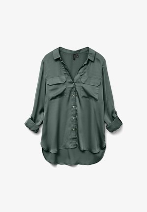 Mörkgrön, silkeslen skjorta med krage, knappknäppning fram och två bröstfickor. Har uppvikta ärmar och något rundad nederkant.