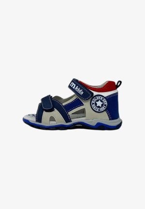 Sandalo blu e bianco con tacco chiuso, punta aperta e cinturino in velcro. Presenta un'etichetta rotonda sul lato e una suola testurizzata.