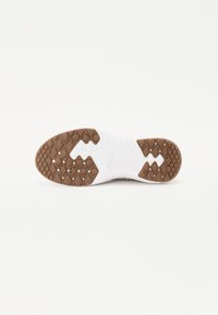 Sola de sapato com uma base branca e seções em borracha castanha. Apresenta um padrão de aderência texturizado com formas hexagonais e circulares.