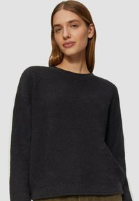 Schwarzer, strukturierter Pullover mit Rundhalsausschnitt, langen Ärmeln und lockerer Passform. Hergestellt aus weichem Material und mit gerippten Details an den Bündchen und dem Saum.