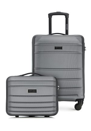 Dwie srebrne walizki z twardą skorupą, jedna duża z teleskopową rączką i kółkami, druga mniejsza z górnym uchwytem, obie z teksturą poziomych żłobień.