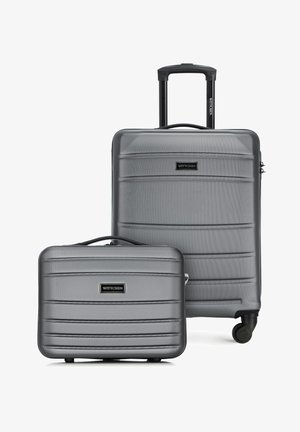 Deux valises rigides argentées, une grande avec poignée télescopique et roulettes, une plus petite avec poignée supérieure, toutes deux texturées avec des stries horizontales.