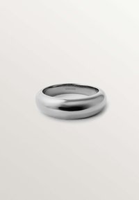 Anillo de metal plata con forma suave y redondeada y acabado pulido. Interior grabado con el nombre de la marca "aristocrazy."