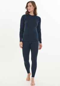 Marinblå termisk långärmad topp och leggings tillverkade av ett mjukt, stretchigt material med kontrasterande grå sidopaneler och turkosa sömnadsdetaljer.