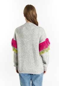 Maglione grigio con frange rosa e verde sulle maniche, dotato di un collo e polsini a costine, con una vestibilità morbida.