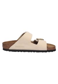 White Birkenstock sandal with a suede upper, featuring a side buckle and a cork footbed, set on a black rubber outsole.