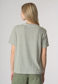 T-shirt a maniche corte a strisce verdi e bianche, realizzata in tessuto leggero, con scollo rotondo e vestibilità comoda.