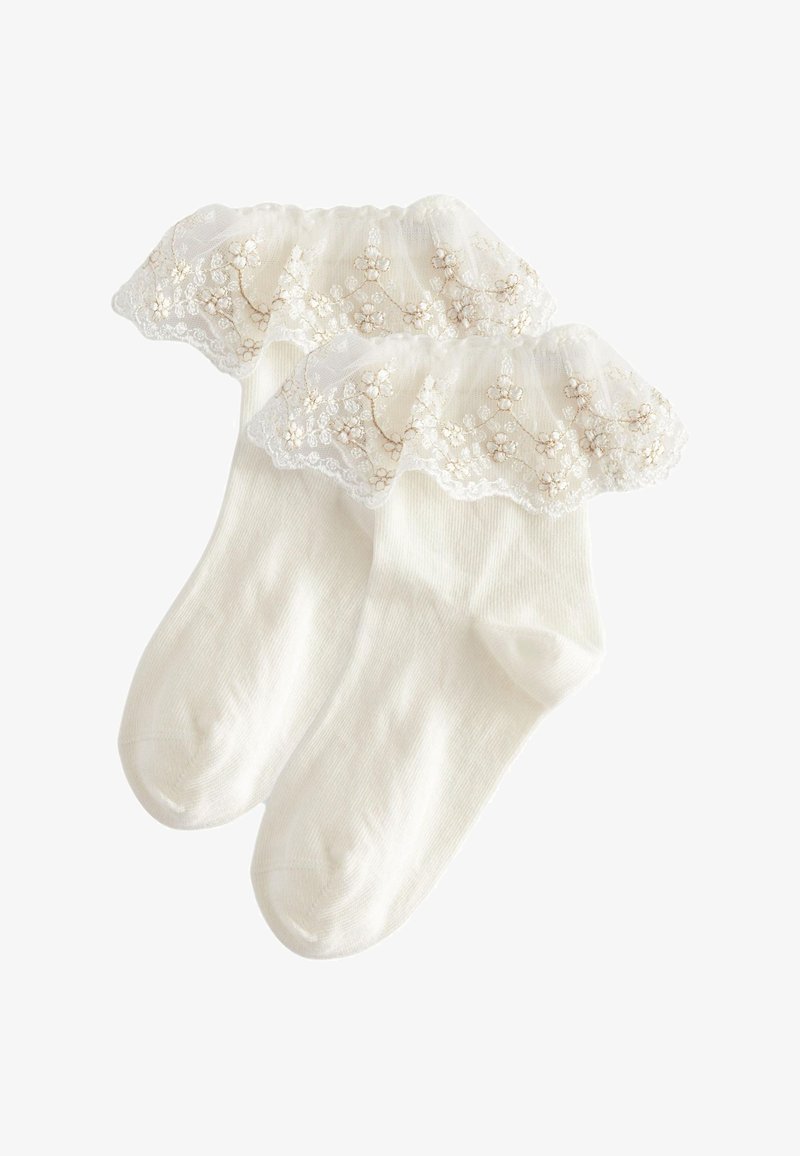 Witte enkelsokken met een ruches bovenkant van kant. Het kant heeft florale borduursels en is versierd met kleine kraaltjes langs de rand.