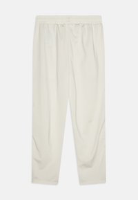 Pantalones deportivos de color beige claro con una cintura elástica, textura suave y diseño de pierna recta. Sin patrones visibles ni detalles de hardware.