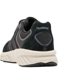 Schwarzer und grauer Sportschuh mit einer strukturierten Wildlederoberfläche, Netzeinsätzen und einer gepolsterten Sole mit einem auffälligen Profilmuster.
