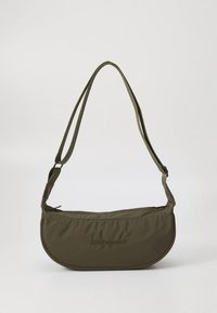 Skuldertaske i olivengrøn med en buet form, lavet af nylon. Har et logo foran og en justerbar rem. Glat tekstur.