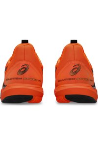Helle orange Tennisschuhe mit einem strukturierten Mesh-Obermaterial, schwarzen Akzenten und "SOLUTION SPEED FF" Branding an den Seiten und der Ferse.