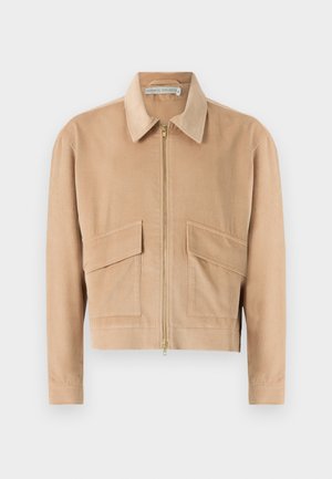 Beige kordfløyelsjakke med glidelås i front, lange ermer, krage og to lommer foran. Har strukturert stoff og en kroppet design.