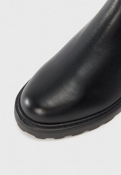 Zwarte leren laars met een afgeronde neus, een gladde textuur en een rubberen zool. Heeft gestikte details rond de zool voor extra duurzaamheid.