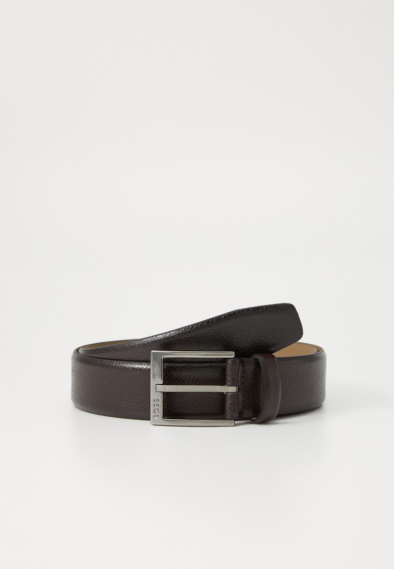 Cinturón de cuero marrón con un acabado texturizado, hebilla de metal plateado y un diseño sencillo. La hebilla presenta una forma rectangular y grabado de la marca.