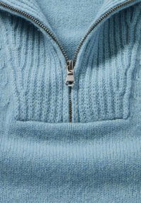 Helles blaues Strickpullover mit einem halben Reißverschluss. Verfügt über eine gerippte Textur am Kragen und einen glatten Körper. Weiches Wollmaterial.