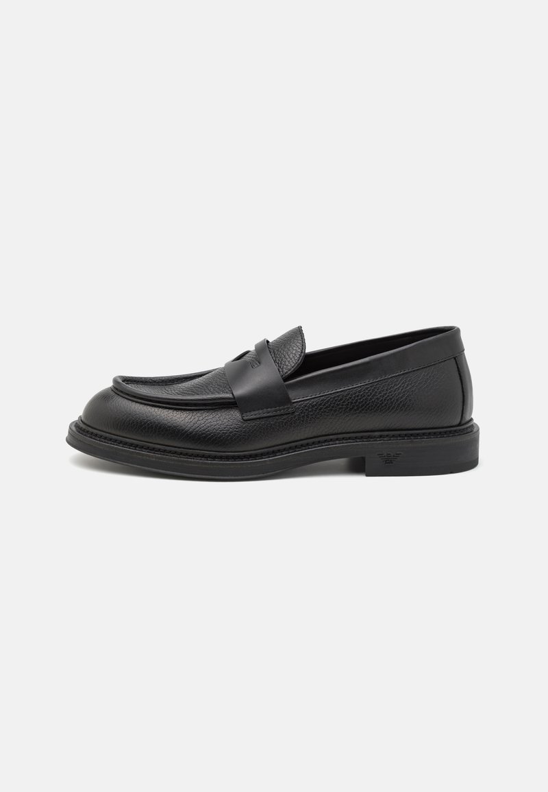 Black leather loafer with a textured upper and smooth overlay strap. Features a rounded toe and low heel, with detailed stitching on the sole.
