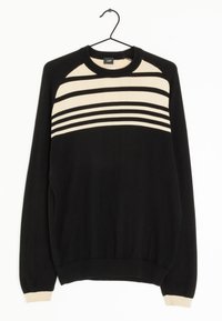 Schwarzer Pullover auf einem Kleiderbügel mit einem cremefarbenen gestreiften Design über der Brust, geripptem Ausschnitt und Bündchen sowie einer weichen Textur.