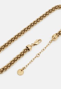 Gold-tone chain necklace featuring interlinked design, a lobster clasp, and a disc charm with a textured rim.