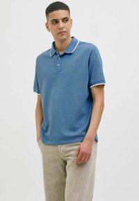 Pácolt kék pamut póló ing fehér gallérral és ujj díszítéssel. Rövid ujjú, laza fazonú, kis logóval a mellkason.