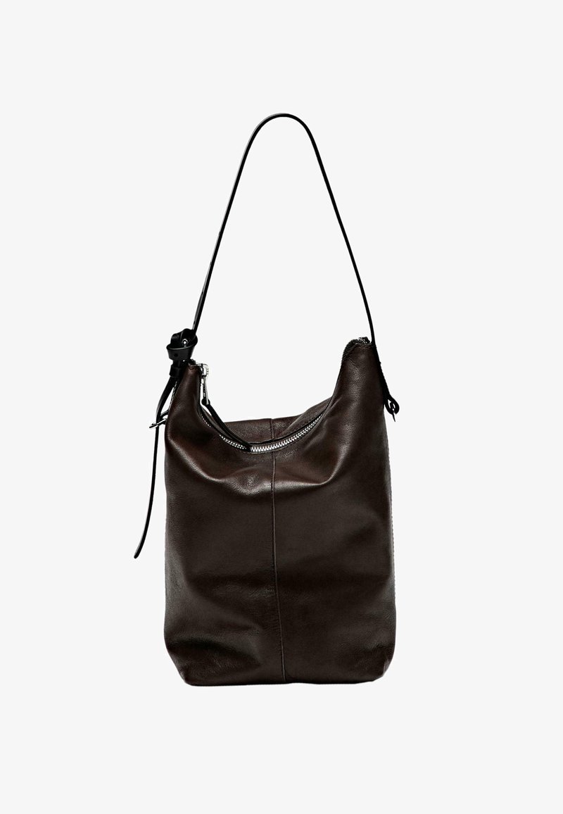 Dark brown leather handbag with a soft texture, rounded shape, single shoulder strap, and zippered top closure. Minimalist design, no patterns.