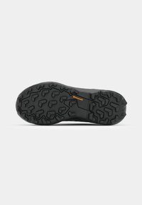 Semelle de chaussure en caoutchouc noir avec motif de bande de roulement angulaire et petit logo orange "Continental" au centre, présentée sur fond blanc.